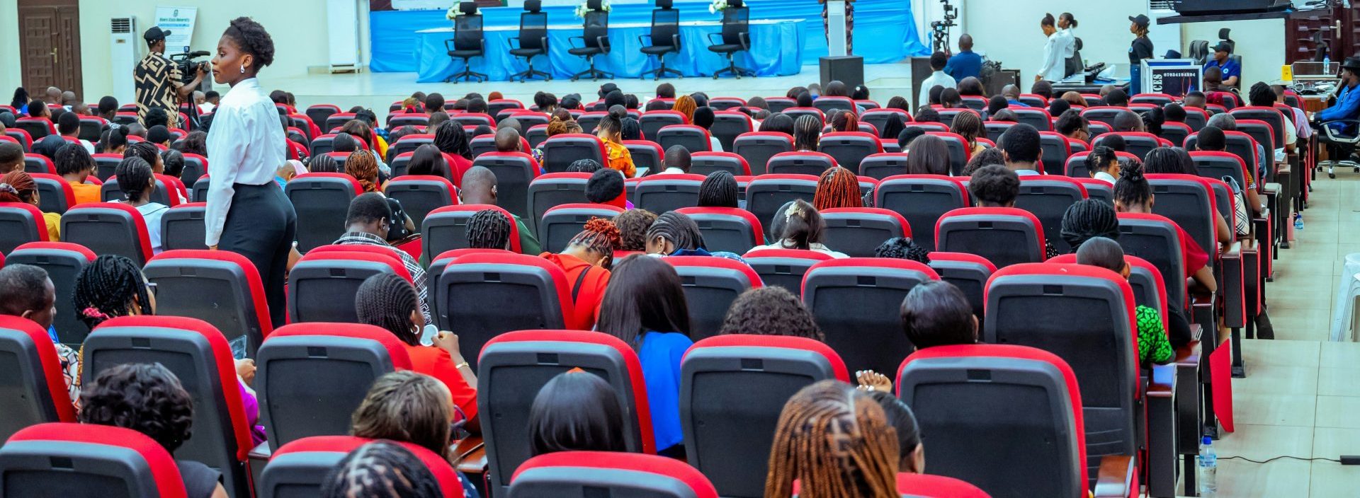 A large auditorium filled with people attending a conference.