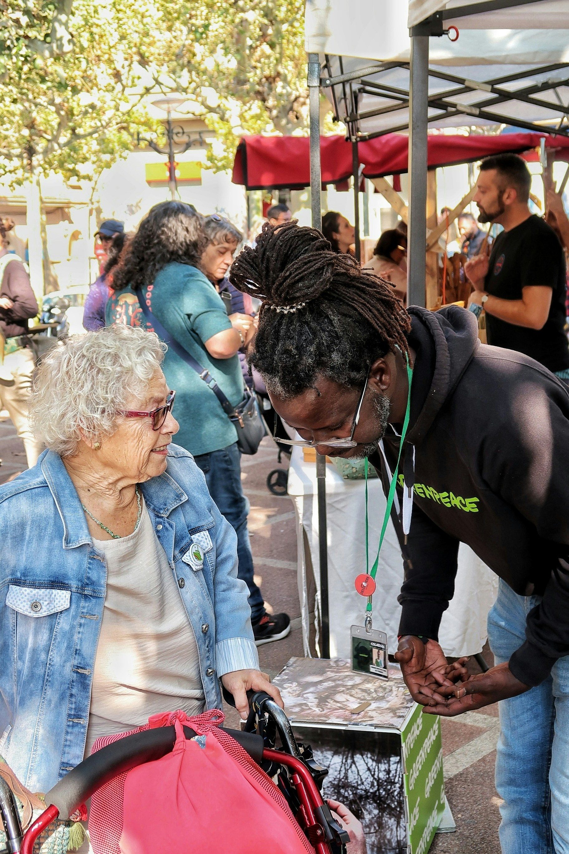 Elderly woman in wheelchair talks to man